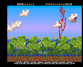 An insect flying over dense green foliage and tall flowers in the opening stage of Apidya.