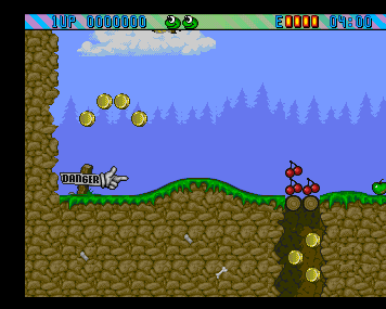 Superfrog's forest stage with golden coins, flowers and grassy platforms beneath a blue sky.